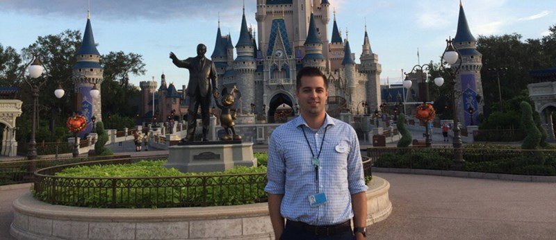 Dean Kennedy standing in front of the Magic Kingdom at Disney World