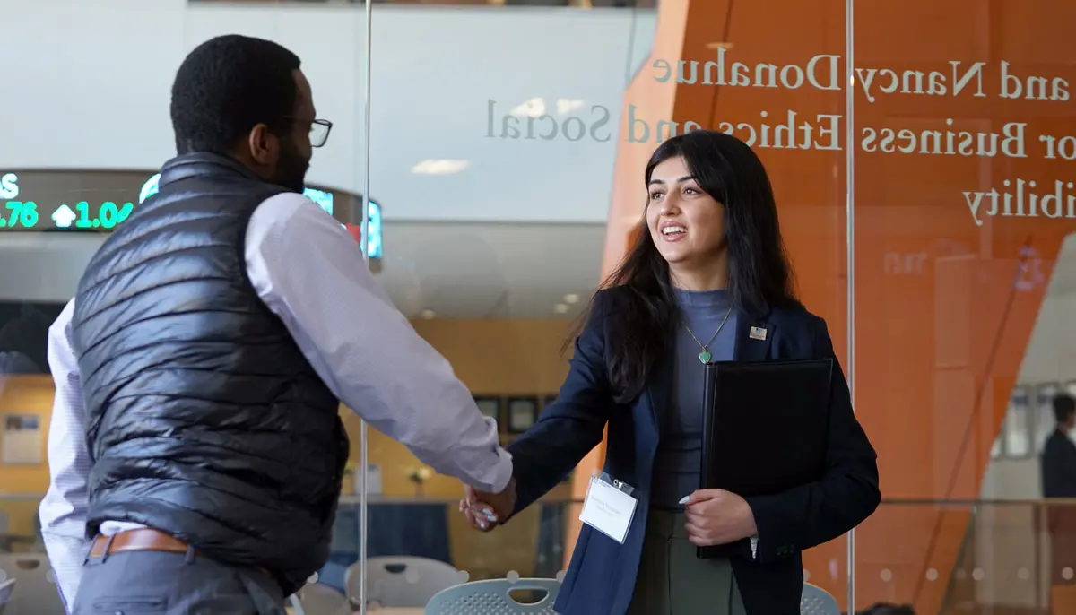 Deeyana Touserkani shakes hands with another person.