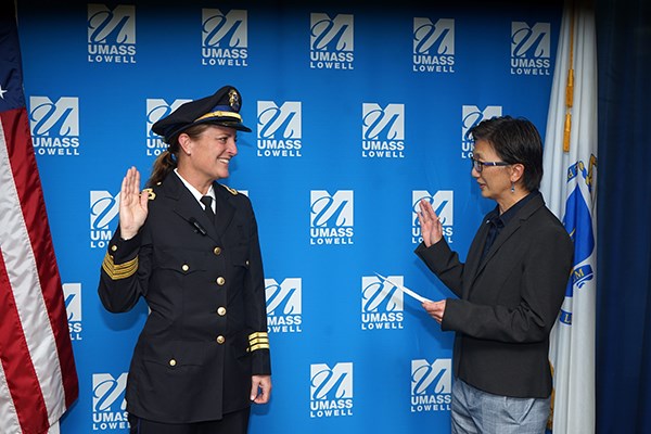 A woman in a police uniform is sworn in by a woman who is holding a piece of paper