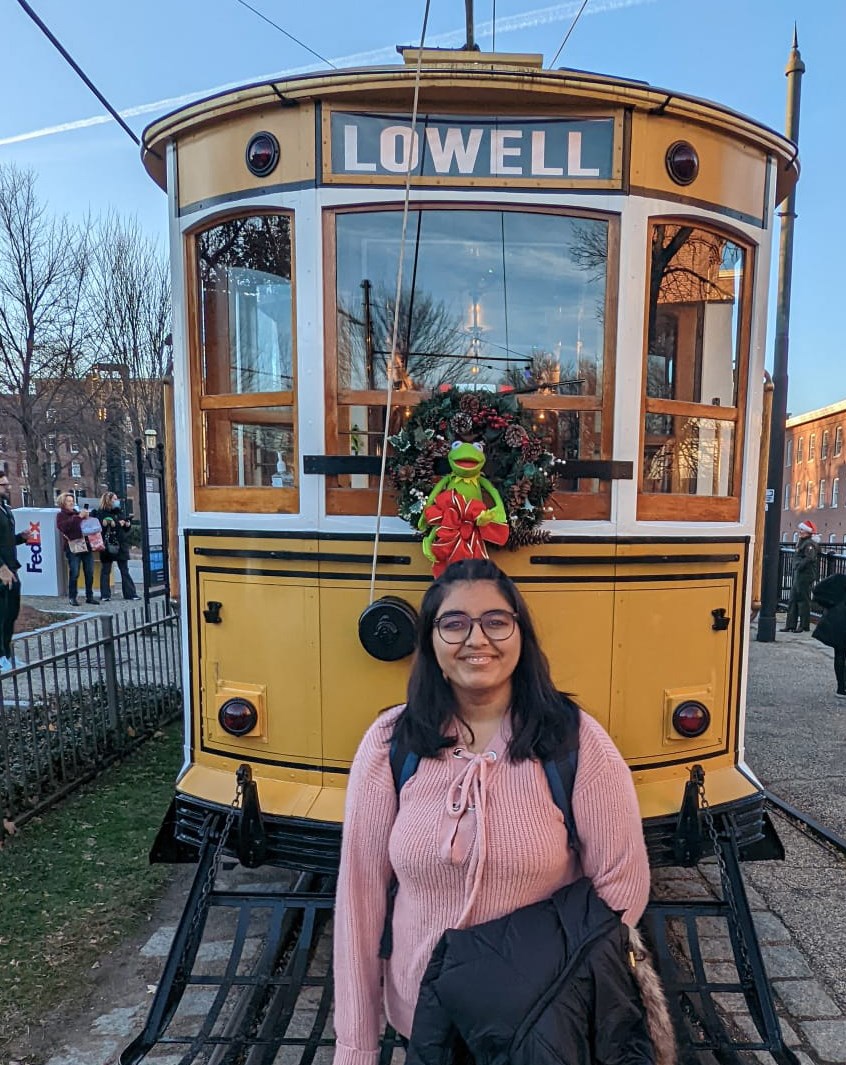 Dhruvi Patel standing in from of a trolley with the word Lowell on it.