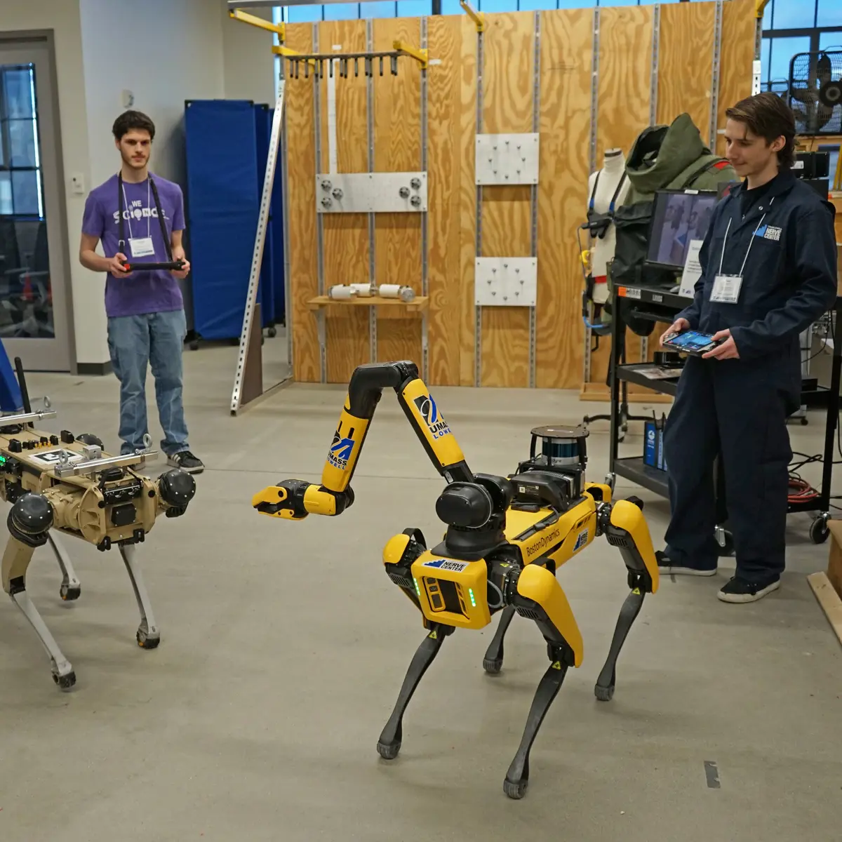 Two Computer Science students controlling dog-like robots in the NERVE center. 