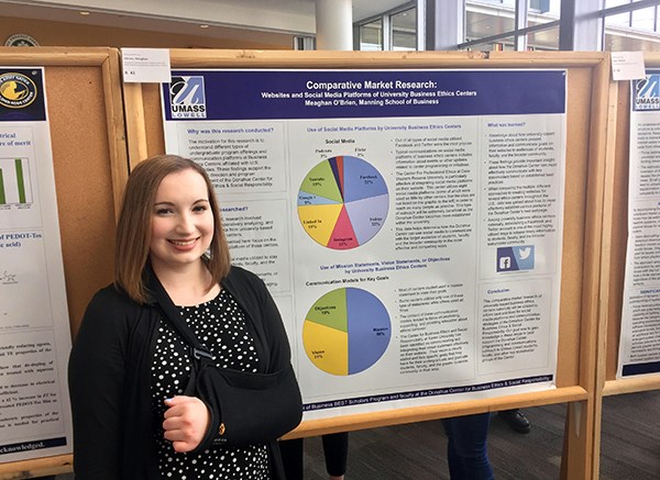 Student Meaghan O’Brien stands in front of her research poster