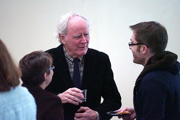 Author James Carroll speaks with a student 