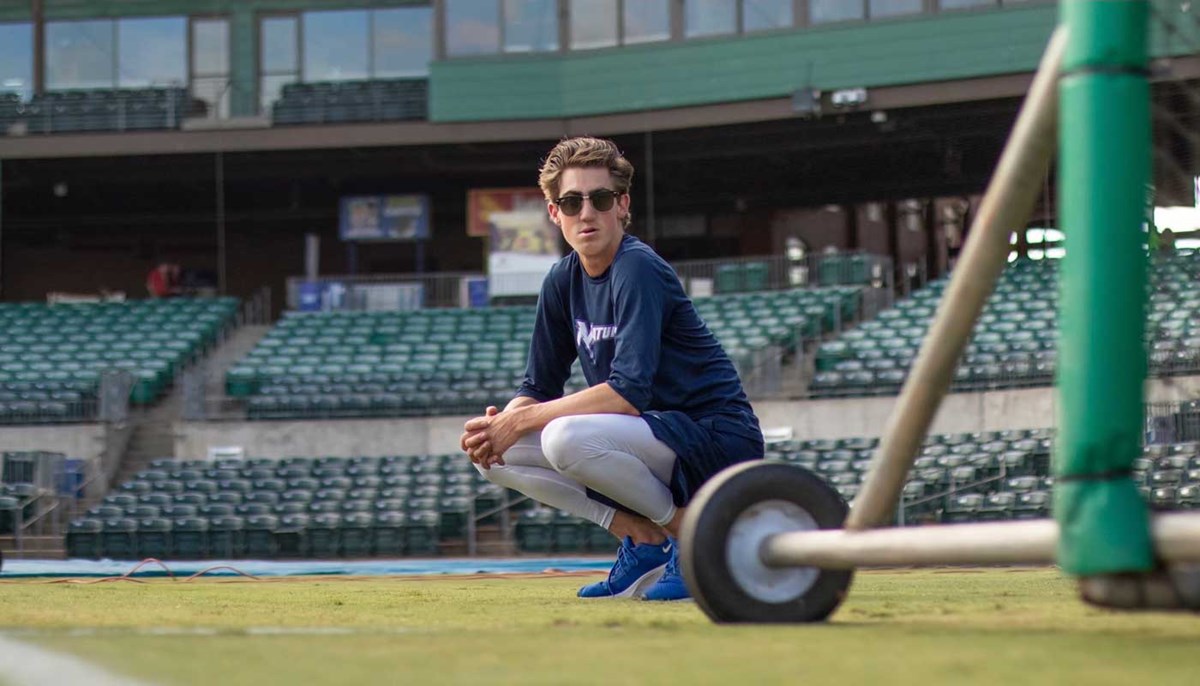 Drew Epperson crouches on an athletic field at UMass Lowell