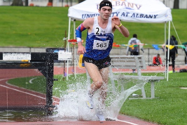 Ben Drezek splashes water while competing in the steeplechase track event