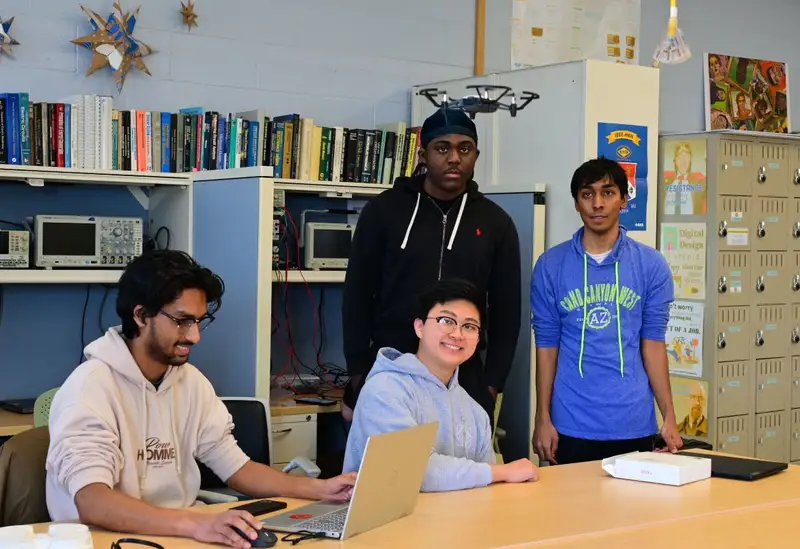 Four students flying a laptop-controlled drone