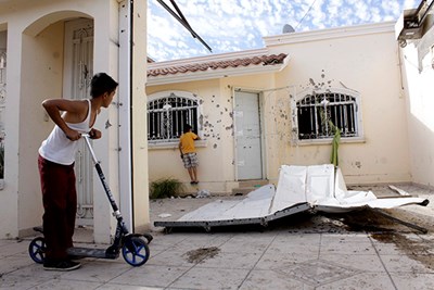 Children in Culiacan, Mexico, look at a safe house where a gun battle betwe...