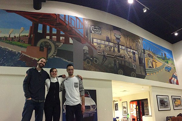 Art students pose in front of their mural at Drum Hill Ford