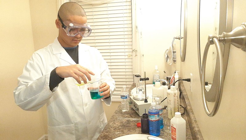 Duc Vu doing a chemistry experiment in his bathroom