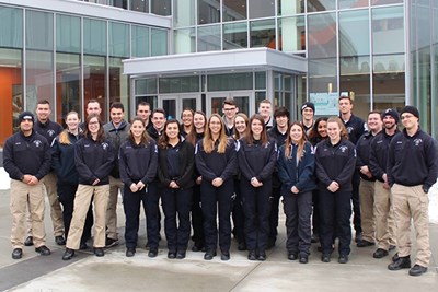 EMS members pose in front of a building