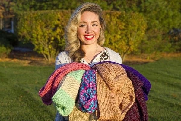  Ashley Bolis, founder of Project Warm & Fuzzy, poses with scarves she has collected so far this year. Eagle-Tribune photo by Amanda Sabga
