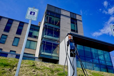 An electric vehicle charging station behind Coburn Hall