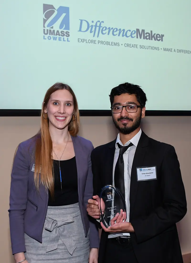 Holly Butler (left) poses with an EV SmarT team member (right) who is holding their Honorable Mention award