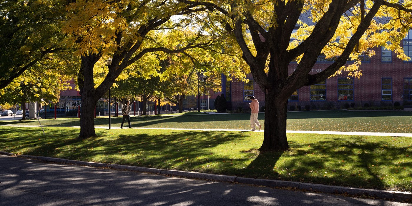 Student walks amid shadows on East Campus