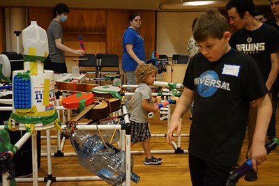 Braeden Roache, right, and his younger brother Jaymason, play the Ecosonic Playground at a summer camp with UMass Lowell student counselors