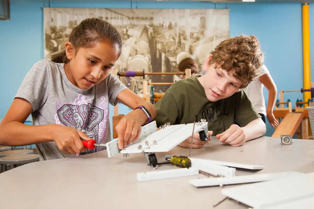 two young students work with tools on a project
