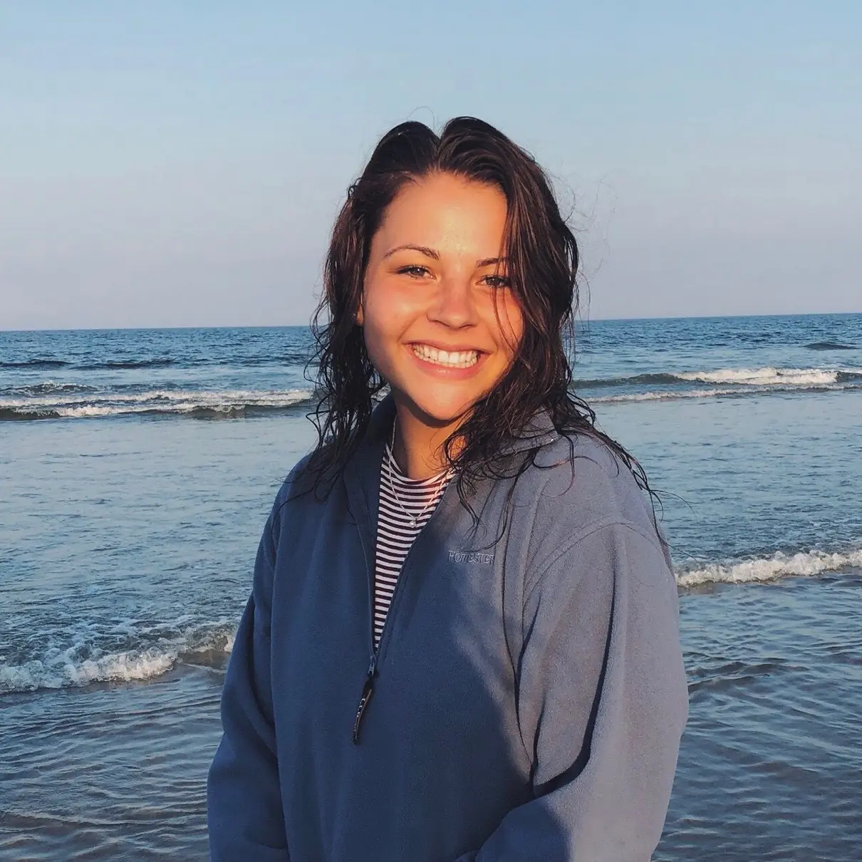 Emily LaBombard smiling with the ocean behind her.