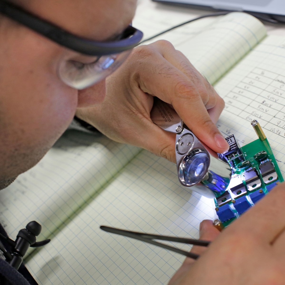Computer engineering student holding circuit or computer component