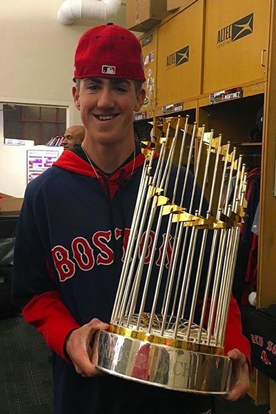 Drew Epperson holds the World Series trophy in the Red Sox clubhouse