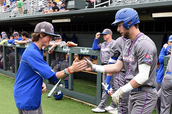 Drew Epperson gives a five to UML baseball player Colby Maiola