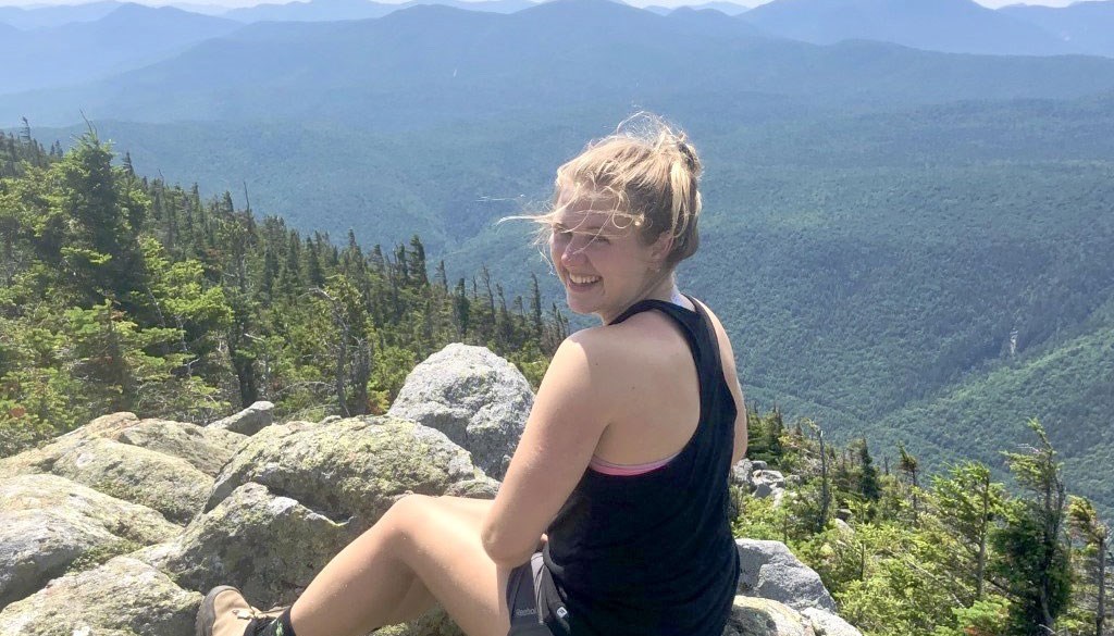 Erin McGuire sits on a mountaintop