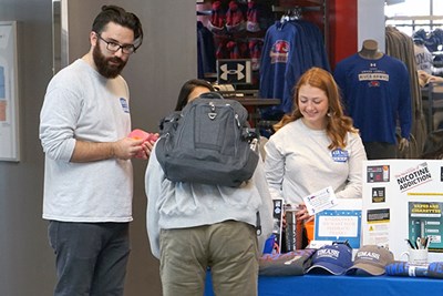 A student enters the massage raffle at the vape exchange table