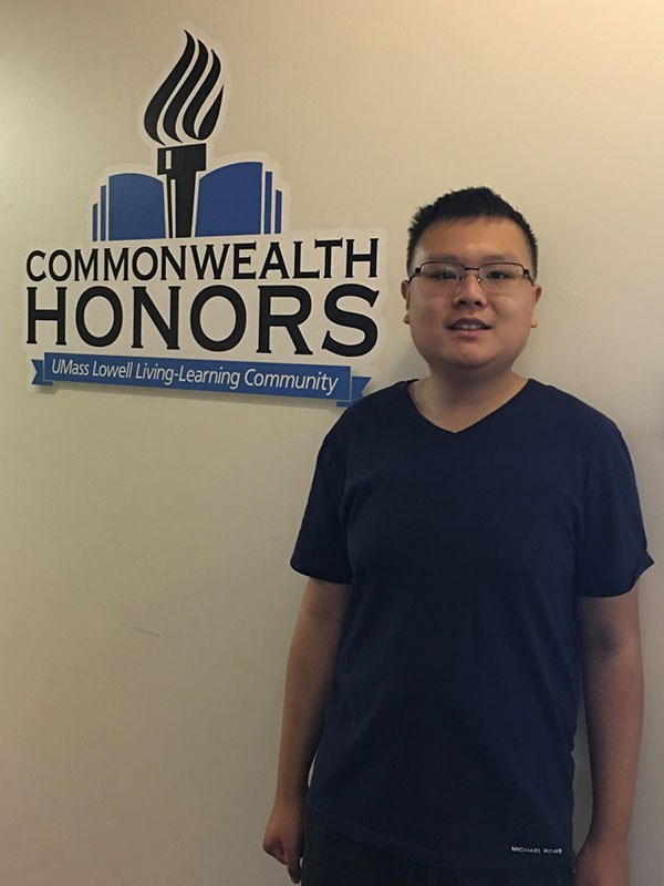 Freshman Evan Yu in front of Commonwealth Honors LLC sign