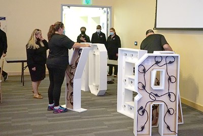 Staff members set up giant white letters before an event