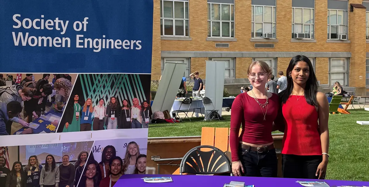 Fatin Rahman posing with another student in front of Society for Women Engineers booth.