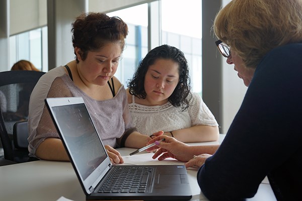 A student and her mother talk with a financial planning advisor