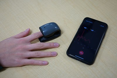 Stephanie Amico monitors her own heart rate using a finger sensor