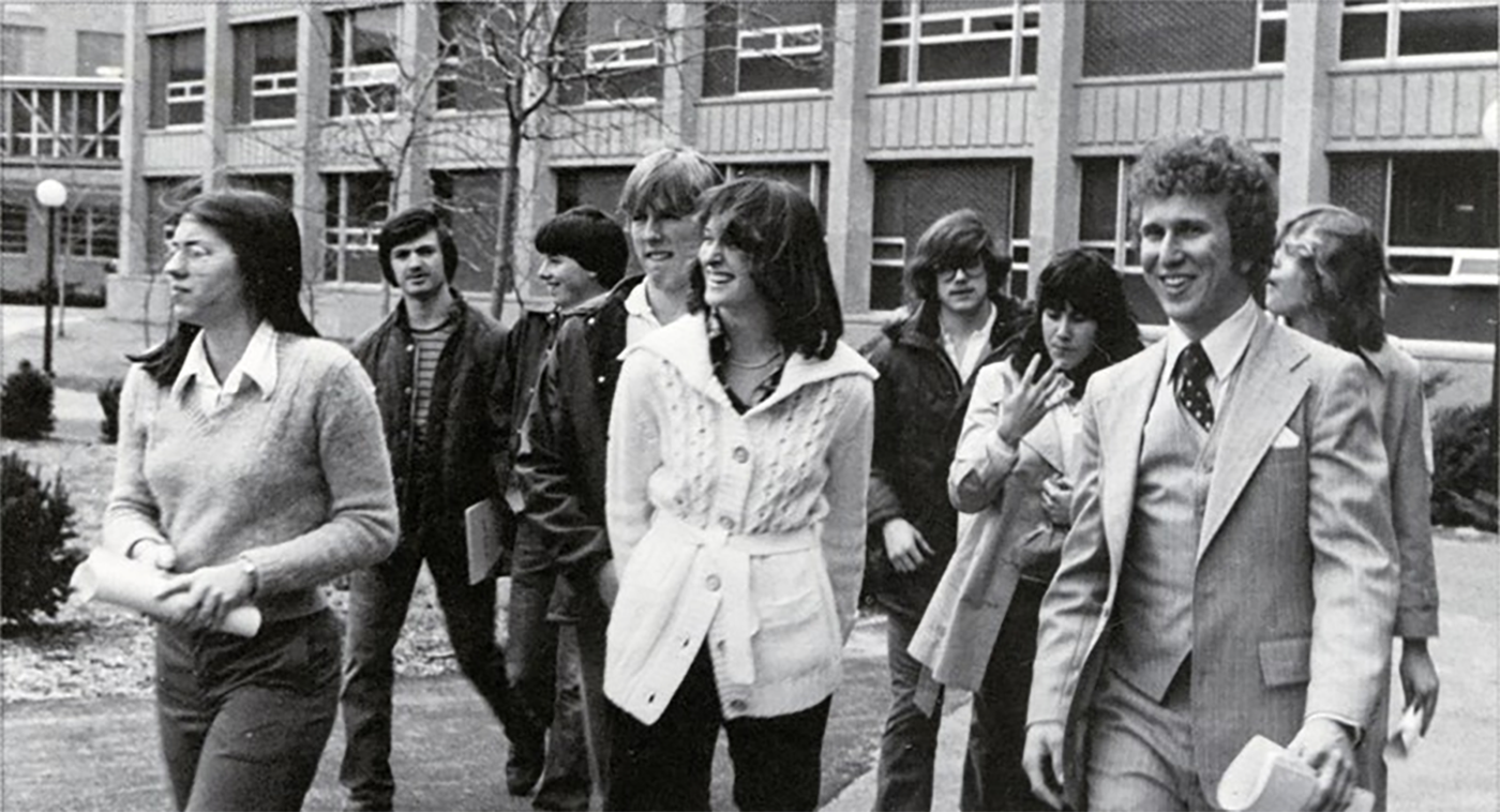 The first class of Nuclear Engineering graduates walk around campus in front of the former Engineering Building.