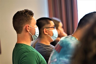 Two students wearing face masks listen in class