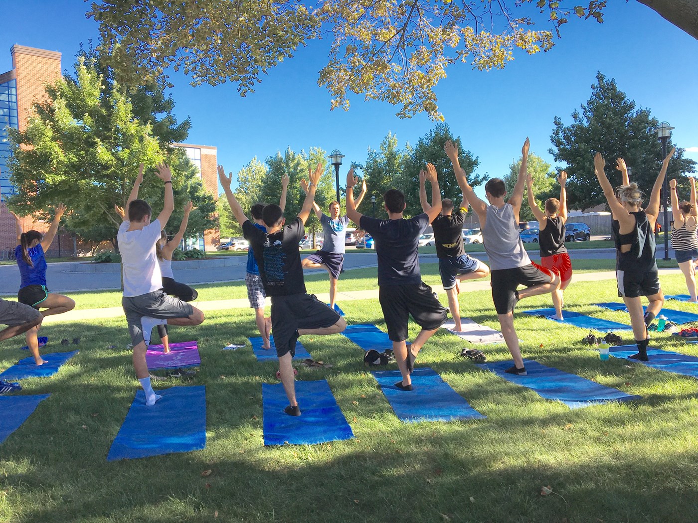 Students doing yoga on front lawn of CRC.