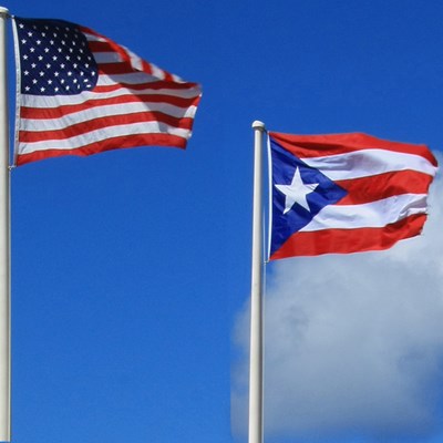 United States and Puerto Rican flags flapping in the wind.