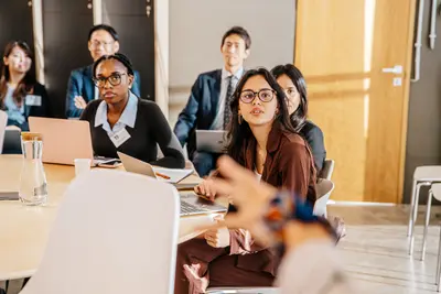 Twenty men and women pose for a group photo in a conference room.