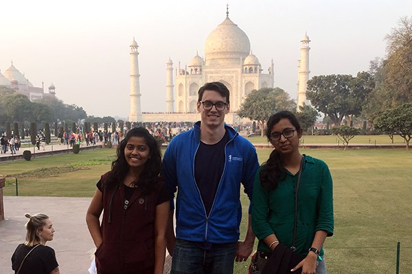 Student Will Hanna stands in front of the Taj Mahal with two students from India