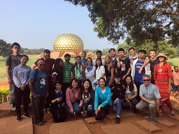 Students pose for a group photo in front of the Matrimandir