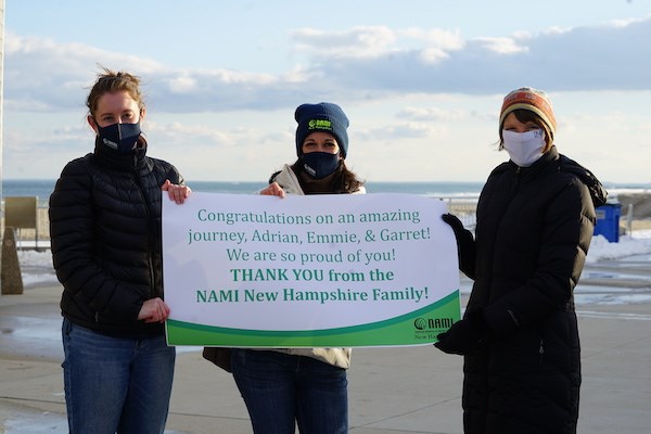 NAMI staff members hold a thank you banner
