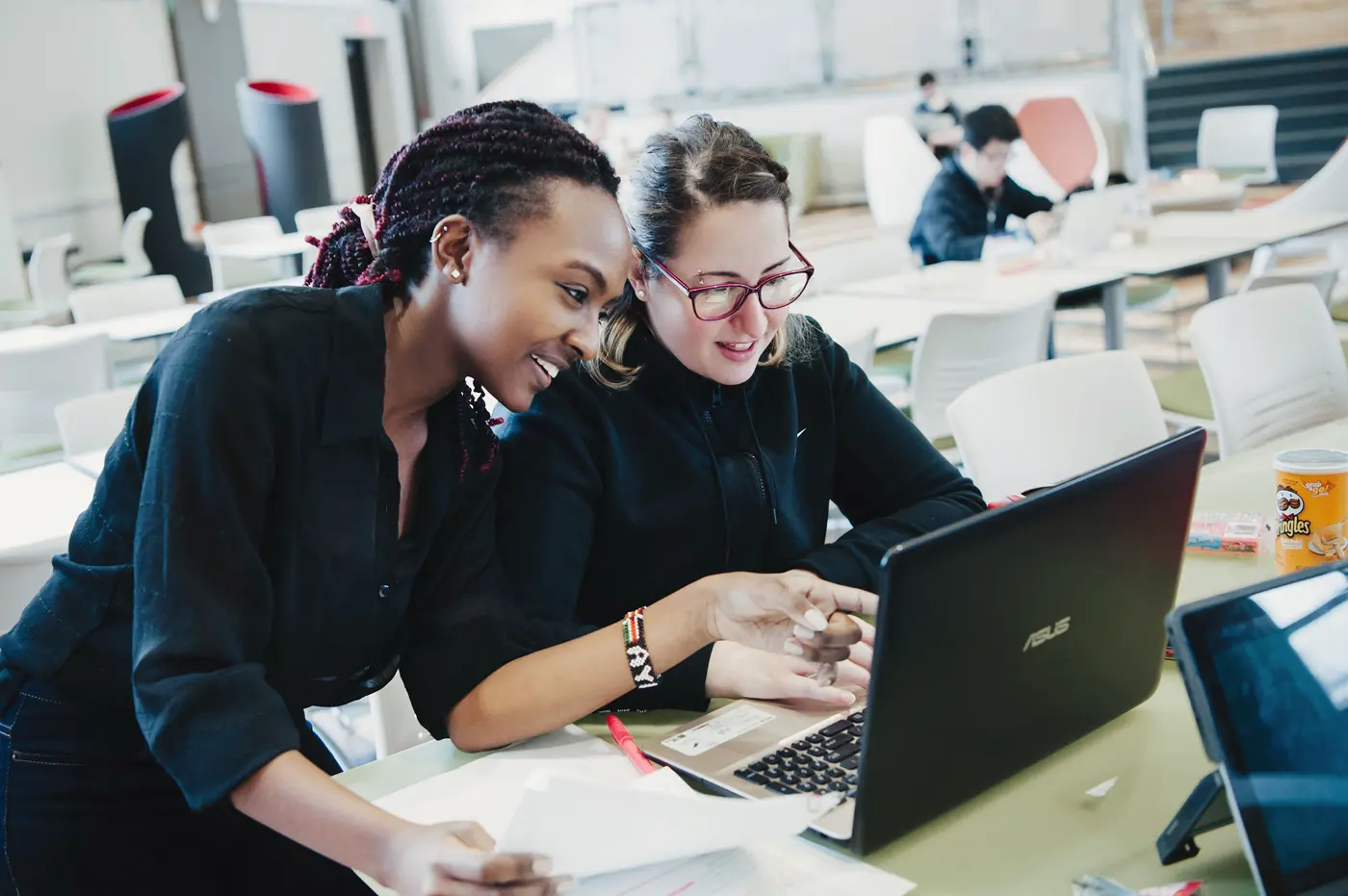 Two young woman look at laptop screen