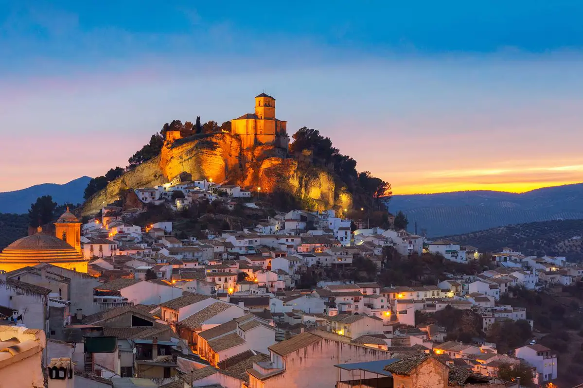 Montefrío's illuminated hilltop church and whitewashed village, Granada..
