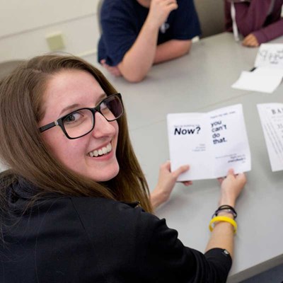 Graphic design student holds a typography booklet in a UMass Lowell studio