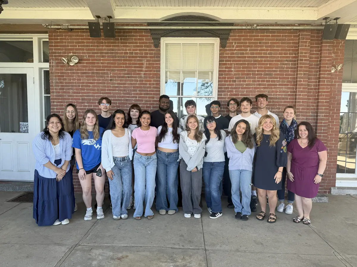 A group of Honors College students stand in front of Allen House.