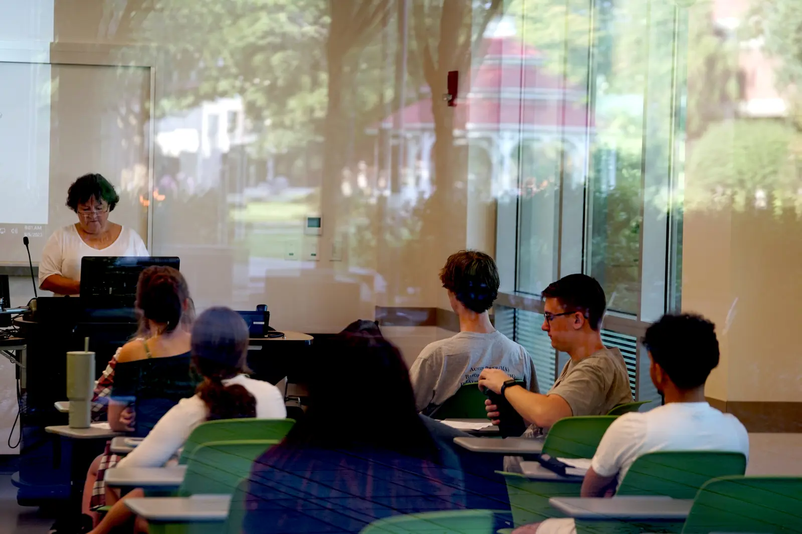 Instructor at podium as students sit in classroom