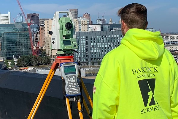 A surveyor from Hancock Associates takes in a view from a city building