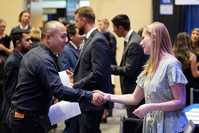 A student shakes hands with a recruiter at the Accounting Career Fair