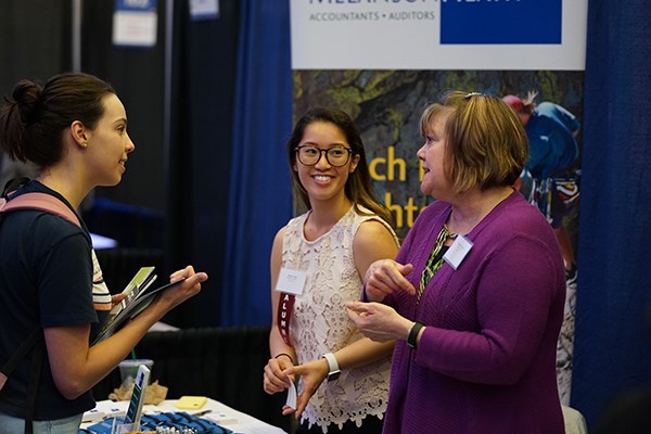 Recruiters from Melanson Heath talk to a student at the Accounting career fair