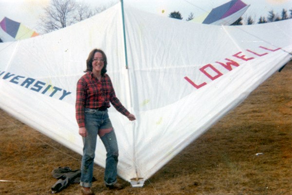 A student poses with their hang glider