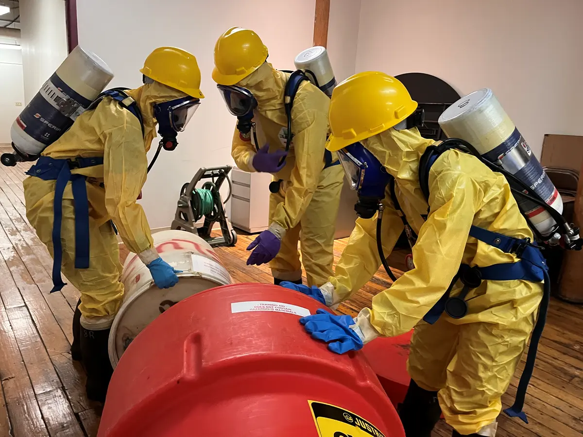 Students cleaning up hazardous materials during a class simulation