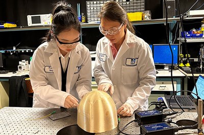 Lidan Cao and Xingwei Wang examine optical sensor fibers in a lab.